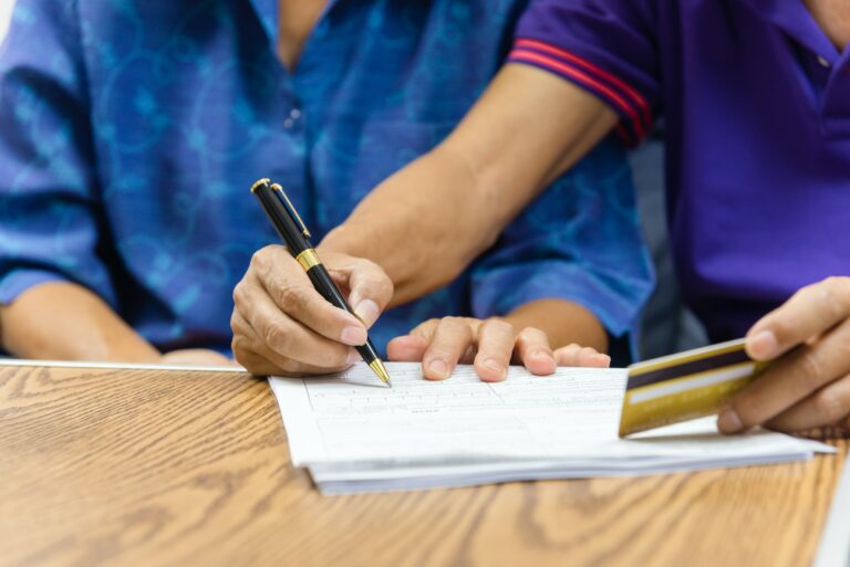 Asian elderly holding pen contract payment credit card insurance health care paperwork