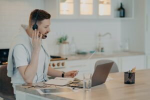 Young guy adjusting headset while learning online at home