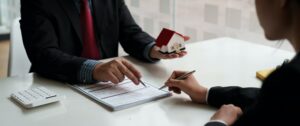 Businessman and estate agent signing a document for house deal